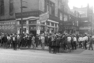 African American men in front of Walgreen Drugs (now called Walgreens) at 35th and S. State St. in the Douglas community area, tags: wall - CC BY-SA